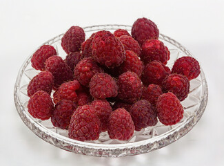 Ripe juicy raspberries close-up in a plate