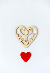 fancy laser cut heart and plain hand painted red heart on a light background