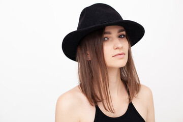 Portrait of a girl with beautiful eyes looking in the camera wearing black hat in the studio