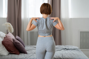 Fototapeta na wymiar Young woman doing morning exercises in the bedroom