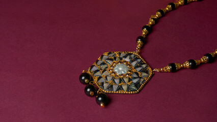Indian traditional antique or retro style pendant on black background.

