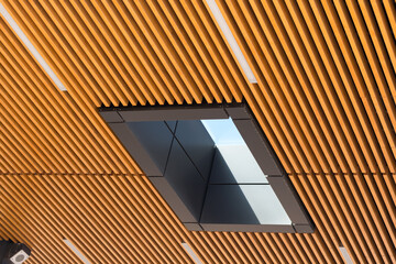 wooden slat drop ceiling and skylight with blue sky beyond 