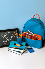 School backpack with colorful school supplies  and blackboard with letters back to school. School...