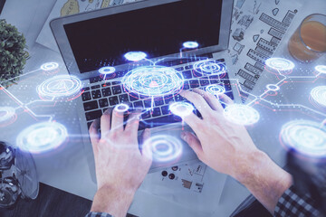 Double exposure of man's hands typing over computer keyboard and social network theme hologram drawing. Top view. People connection web concept.