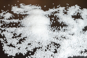 White plastic beads on black background, Polymers bead or polymer resin, polymer pallet, Product from petrochemical plants. granules polymer,