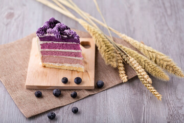 Close up slices of blueberry layer cakes on a wood tray in coffee or tea time. Dessert for Wedding, Birthday and Celebration concept.