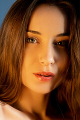 Fototapeta premium Attractive woman. Natural beauty. Facial rejuvenation. Healthy skin. Close up portrait of appealing young female with clean smooth flawless face in warm light.
