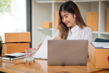 Small Business SME entrepreneur of Young Asian women working with laptop for Online shopping at home,Cheerful and Happy with box for packaging in home,Own Business Start up for Online shopping