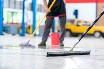 Select the focus mop, service staff man using a mop to remove water in the uniform cleaning the...