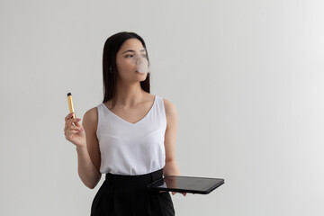 beautiful, modern brunette smokes an electronic cigarette