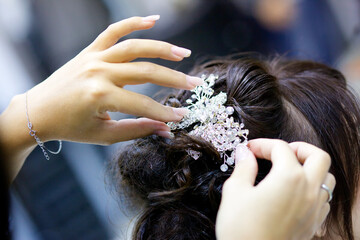 Hands dress up a luxurious tiara for a bride or princess close-up. Jewelry accessories.