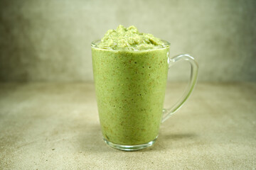 Green healthy vegetable smoothie in the glass cup