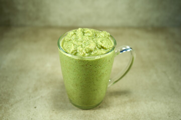 Green vegetable smoothie in glass cup