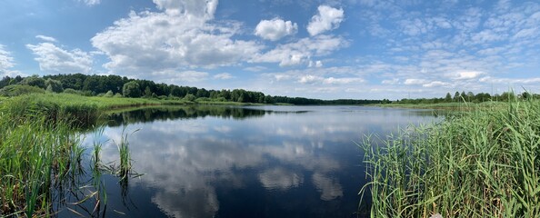 Panoramic view of the lake, blue sky with clouds.