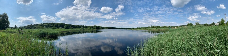 Obraz na płótnie Canvas Panoramic view of the lake, blue sky with clouds.