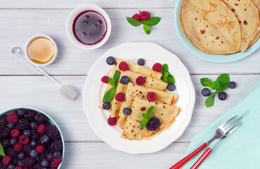 Crepes with berries, breakfast, selective focus, on a white wooden table, horizontal, no people,