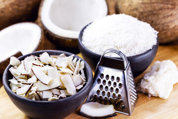 coconut chips, with grated coconut and other culinary ingredientsnt, with ripe coconut in the background