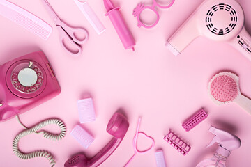 Hairdresser's equipment and accessories isolated on a vibrant pink background. Plastic scissors,...
