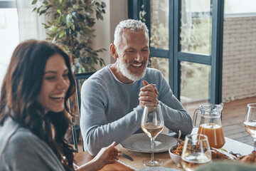 Happy family communicating and smiling while having dinner together