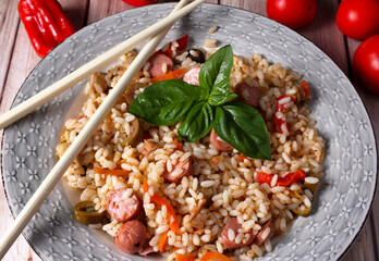 Delizioso piatto con una salutare insalata di riso, verdure miste e wurstel tagliati a pezzi.