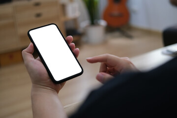 Closed up with male using phone in living room, empty screen of smartphone.