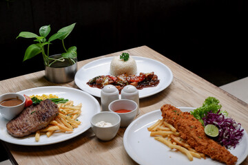 Sirloin steak, catfish and chips, and chicken black pepper. Food menu on the table