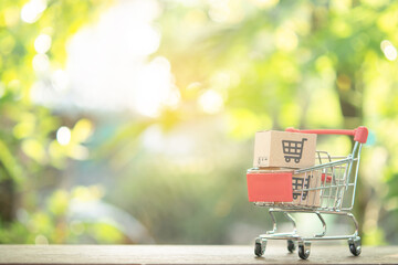 Shopping concept - Shopping cart or trolley and Paper cartons or parcel with a shopping cart logo...