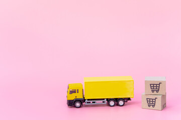 Logistics, and delivery service - Cargo truck and paper cartons or parcel with a shopping cart logo on Pink background. Shopping service on The online web and offers home delivery.