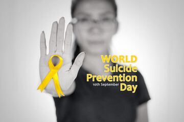 Woman show yellow ribbon and hand gesture to stop