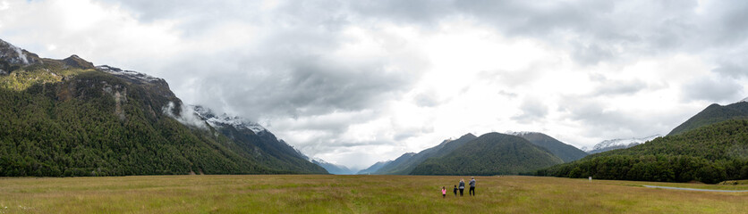 A family anjoying the panoramic view of Eglinton valley, Milford Sound highway passing through, New Zealand