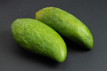 Fresh green mango fruit on dark background
