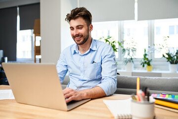 Young man freelancer working on laptop from home office