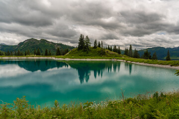 Fototapeta na wymiar Nice blue green lake on big mountains in Austria summer cloudy day
