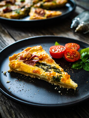 Tart with asparagus and serrano ham on wooden table
