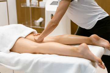 Obraz na płótnie Canvas Middle-aged woman having a leg massage in a beauty salon.