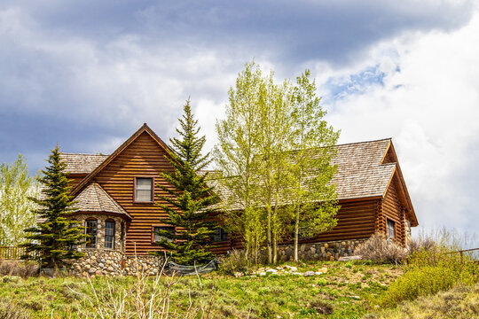 Luxury Log Cabin With Wooden Roof And Rock Bay Window On Hilltop Surrounded By Pines And Quaking Aspens