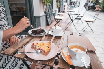 Eine Frau isst Schokoladenkuchen im Straßencafé.Niederlande Holland.
