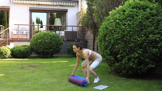 Sporty young woman going for fitness workout in garden, go to yoga class on sunset.