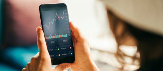 Woman using cell phone investing application. Stock market investment app in hand. Screen close-up