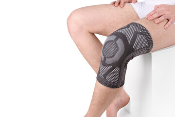 Knee Support Brace on leg isolated on white background. Orthopedic Anatomic Orthosis. Braces for knee fixation, injuries and pain. Orthotics. Foot orthosis. Knee Joint Bandage Sleeve. Elastic Sports