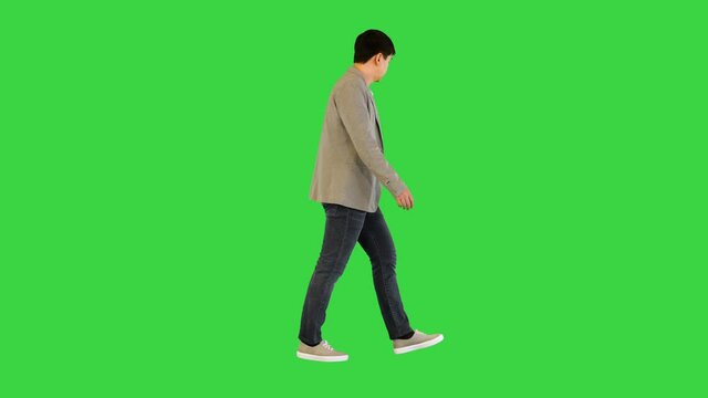 Young asian man in casual clothes walks looking around on a Green Screen, Chroma Key.