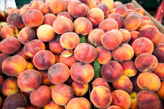 Heap of fresh ripe peaches at local farmers market