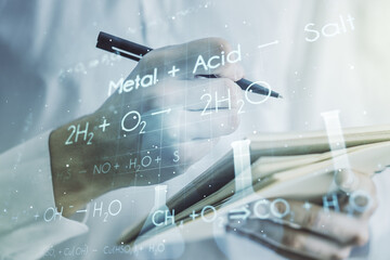 Double exposure of creative chemistry concept with man hand writing in notebook on background, research and development concept