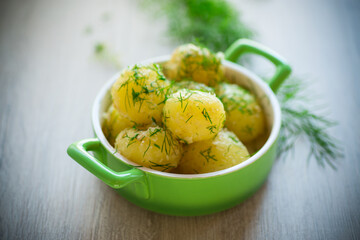 boiled early potatoes with butter and fresh dill in a bowl