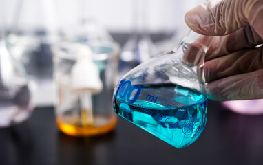 laboratory test tubes with samples Scientists hold a beaker with a blue liquid in their hands. biological chemistry experiment Environmental studies and data analysis.	