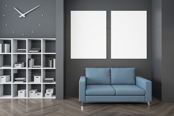 Modern waiting area in office with bookcase, comfortable blue couch, wooden flooring and empty...