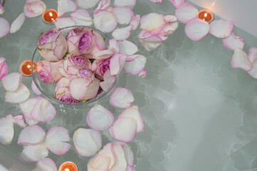 white pink roses and candles in the bathroom, spa treatments, relaxation evening