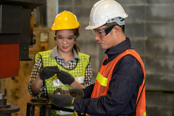 Selective Focus. Supervisor, Technician worker working in heavy Industry manufacturing factory on business day. Industrial engineers have to consult with colleagues. Workplace gender equality concept