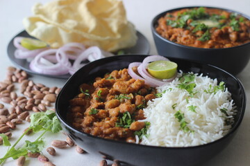 Red kidney beans in a thick and spicy gravy of onions and tomatoes served along with steamed basmati rice and papad. Commonly known as rajma masala and chawal in the northern parts of India.