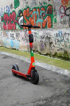 Electric scooter of Lime brand by Uber, along graffiti wall in Bucharest on June 22, 2021